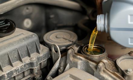 person adding oil to engine