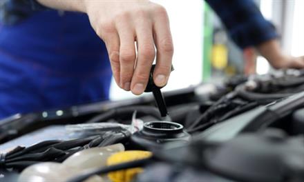 person checking vehicle fluids